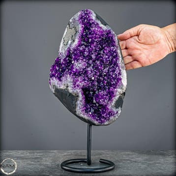 Gloeiende amethist op metalen standaard – elegantie in