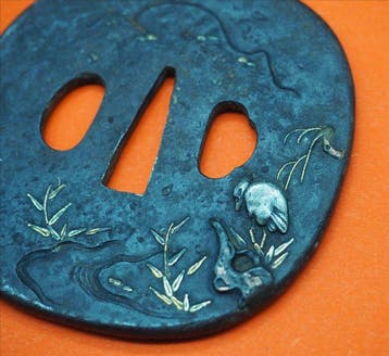 Tsuba van ijzer met figuratieve decoratie in zgan - IJzer