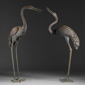 Levensgrote paar tuindecoraties in de vorm van kraanvogels.