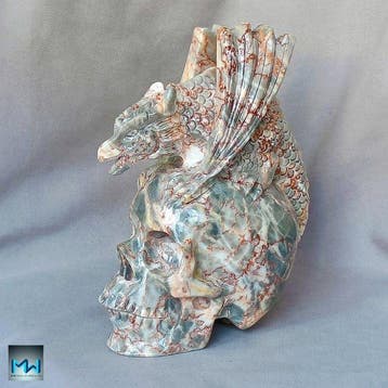 Sculptuur van een draak boven een menselijke schedel, met de