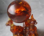 3 Baltische amber Sphynx katten die een amberbal vasthouden