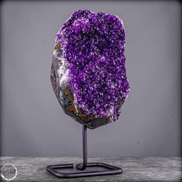 Gloeiende amethist op metalen standaard – elegantie in