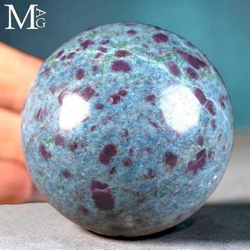 Blauwe kyanietbol met heldere robijninclusies uit India.