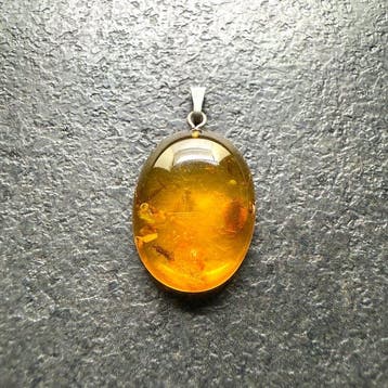 Oude hanger met Baltisch amber cabochon, die lijkt op een