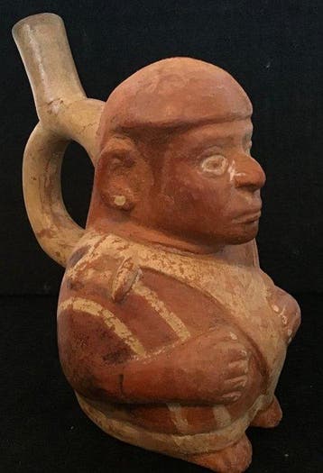 Moche-figuur van een zittende man die een tas met