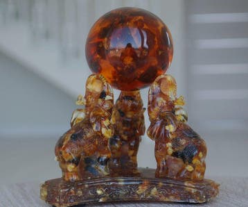 3 Baltisch Amber-olifanten die een Amberbal vasthouden -