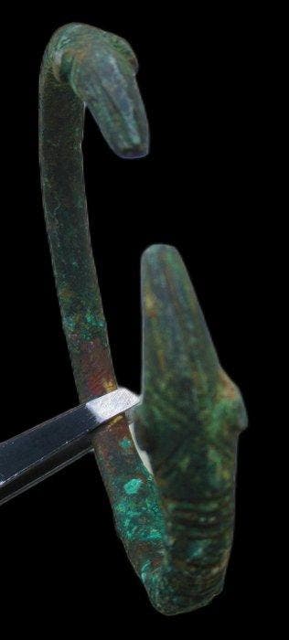 Viking periode Oud bronzen armband met slangenkop-uiteinden,
