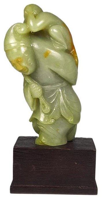 A Chinese Celadon Jade Carving of a Monkey and Man Group,