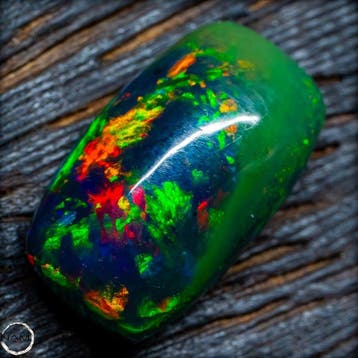 Zwarte opaal cabochon – spectaculair vuur in groen, blauw en
