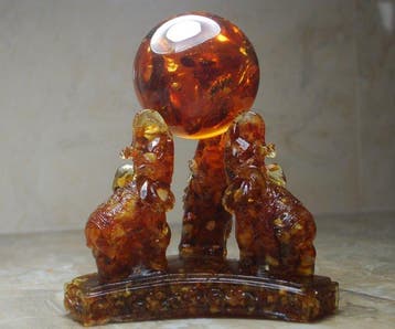 3 Baltisch Amber-olifanten die een Amberbal vasthouden -