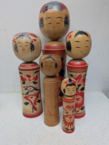 Een set vintage kokeshi-poppen in de klassieke Naruko-stijl
