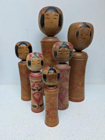 Een set vintage kokeshi-poppen in de klassieke Naruko-stijl