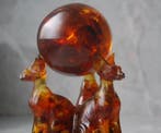 3 Baltische amber Sphynx katten die een amberbal vasthouden