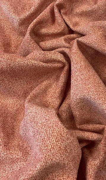 Zacht zalmkleurig geweven stof met roze ondertoon, gemaakt