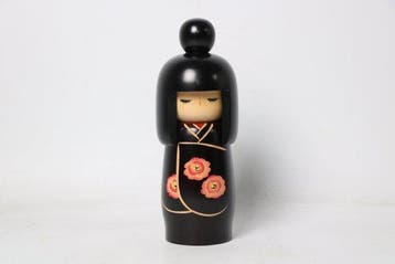 Zwarte kokeshi-pop met camelia — werk bekroond met de