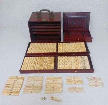 Antieke mahjongset van bot en bamboe met houten kast met