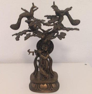 Grote bronzen figuur van Krishna met fluit onder een boom en