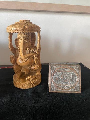 Ganesha-beeld uit hout gesneden en islamitische postbode in