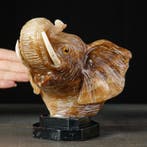 Handgesneden onyx olifantshoofd op zwarte marmeren sokkel -