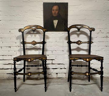 Stoel (2) - Een paar eboniserende stoelen met beeninleg. -