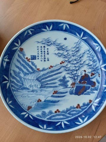Bord van blauwwit porselein en koperrood, scène van een
