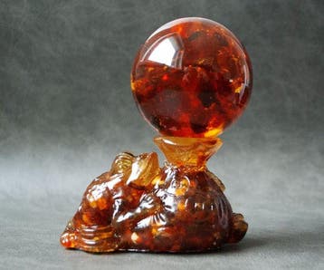 Kikker en Geldtasje Fortuin houden een amberbal vast. -, Verzamelen, Mineralen en Fossielen